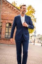 Stylish handsome man with beard, wearing elegant suit outdoor on the city street Royalty Free Stock Photo