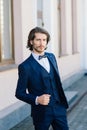 Stylish handsome man with beard, wearing suit jacket and shirt, outdoors on the city street Royalty Free Stock Photo