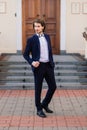 Stylish handsome man with beard, wearing suit jacket and shirt, outdoors on the city street Royalty Free Stock Photo