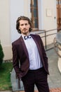 Stylish handsome man with beard, wearing suit jacket and shirt, outdoors on the city street Royalty Free Stock Photo