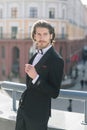 Stylish handsome man with beard, wearing suit jacket and shirt, outdoors on the city street Royalty Free Stock Photo