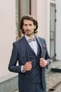 Stylish handsome man with beard, wearing suit jacket and shirt, outdoors on the city street Royalty Free Stock Photo