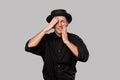 Stylish handsome man a black shirt and pork pie hat having problems isolated over grey background. Royalty Free Stock Photo