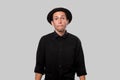 Stylish handsome man a black shirt and pork pie hat isolated over grey background Royalty Free Stock Photo