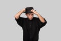 Stylish handsome man a black shirt and pork pie hat isolated over grey background Royalty Free Stock Photo