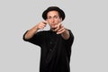 Stylish handsome man a black shirt and pork pie hat isolated over grey background Royalty Free Stock Photo