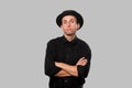 Stylish handsome man a black shirt and pork pie hat over grey background Royalty Free Stock Photo