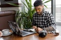 Stylish handsome man photographer freelancer working by laptop computer in cafe