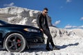 Stylish handsome man posing with car. Elegant young businessman. Royalty Free Stock Photo