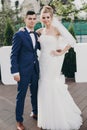 Stylish happy bride and groom posing at big love word in evening light at wedding reception outdoors. Gorgeous wedding couple of Royalty Free Stock Photo