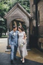 Stylish happy bride and groom walking on background of church in sunny street. Provence wedding. Beautiful emotional wedding Royalty Free Stock Photo