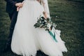 Stylish happy bride and groom walking in yard and holding hands at wedding ceremony. romantic moment, space for text. luxury Royalty Free Stock Photo