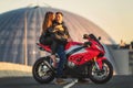 Young couple riding the red sports motorcycle at bridge on sunrise Royalty Free Stock Photo