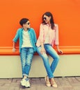 Stylish happy smiling mother with son teenager look at each other posing together in sunglasses, checkered shirts, jeans in the Royalty Free Stock Photo