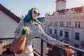 Stylish happy woman wearing green retro shawl with sunglasses holding spring flowers. Classic vintage outdoor fashion Royalty Free Stock Photo