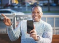 Stylish happy young african american man in a gray sweater sitting on a bench and talking in a smartphone, video communication on Royalty Free Stock Photo