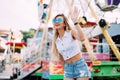 Stylish happy young woman wearing short denim shorts and a white T-shirt. brightred lips . portrait of smiling girl in sunglasses Royalty Free Stock Photo