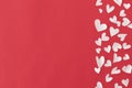 Stylish hearts border on red background flat lay with space for text. Happy Valentine`s Day! Cute little white hearts cut outs on