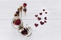 stylish hearts in glass jar and roses on rustic white wooden background. happy valentines day concept. greeting card flat lay wit Royalty Free Stock Photo