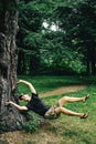 Stylish hipster boy levitating and having fun at tree in woods i Royalty Free Stock Photo