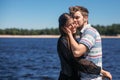 Stylish hipster couple gently hugging at windy river in summer c Royalty Free Stock Photo