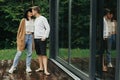 Stylish hipster couple hugging and kissing on wooden terrace, relaxing in cabin in mountains. Happy young family in modern outfits