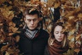 Stylish hipster couple posing under yellow leaves in autumn park Royalty Free Stock Photo