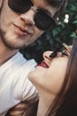 Stylish hipster couple in sunglasses smiling and making cool selfie. Happy family couple in love making self portrait and kissing