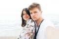 Stylish hipster couple taking selfie on beach at evening sea. Summer vacation. Portrait of happy young family on honeymoon on Royalty Free Stock Photo