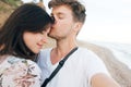 Stylish hipster couple taking selfie on beach and kissing at evening sea. Summer vacation. Portrait of happy young family on Royalty Free Stock Photo