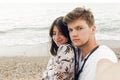 Stylish hipster couple taking selfie and embracing on beach in evening. Happy family relaxing on honeymoon at sea. Summer vacation Royalty Free Stock Photo