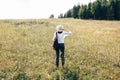 Stylish hipster girl with backpack traveling in sunny mountains. Woman in hat exploring and hiking on top of mountain in sunny Royalty Free Stock Photo