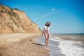 Stylish hipster girl relaxing on beach and having fun.  Happy young boho woman walking and smiling in sea waves in sunny warm day Royalty Free Stock Photo