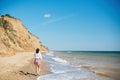 Stylish hipster girl relaxing on beach and having fun.  Happy young boho woman walking and smiling in sea waves in sunny warm day Royalty Free Stock Photo