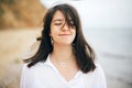 Stylish hipster girl relaxing on beach. Summer vacation. Portrait of  happy boho woman enjoying time and smiling at windy sea. Royalty Free Stock Photo