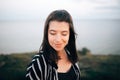 Stylish hipster girl relaxing on beach at sunset. Summer vacation. Portrait of  happy boho woman enjoying evening time and smiling Royalty Free Stock Photo