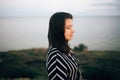 Stylish hipster girl relaxing on beach at sunset. Summer vacation. Portrait of  happy boho woman enjoying evening time and smiling Royalty Free Stock Photo