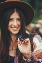 stylish hipster,happy woman in hat holding apatura iris on fingers in forest in mountains. beautiful butterfly on girl hand.