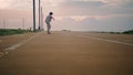 Stylish hipster jumping skate board on sunset ocean. Skater boy enjoying speed