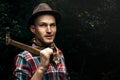 stylish hipster lumberjack with ax in the sunny forest in mountains Royalty Free Stock Photo