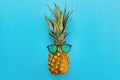 Stylish hipster pineapple in sunglasses on trendy blue paper bac