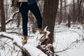 Stylish hipster traveler nubuk shoes on tree in winter snowy for