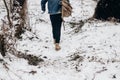 Stylish hipster traveler walking in nubuk shoes in winter snowy