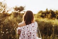 Stylish hipster woman with eco bag walking into sunlight among w Royalty Free Stock Photo
