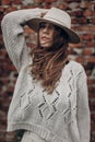 Stylish hipster woman posing in knitted sweater on background o Royalty Free Stock Photo