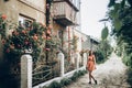 Stylish hipster woman standing at beautiful pink and red roses o Royalty Free Stock Photo