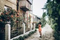 Stylish hipster woman standing at beautiful pink and red roses o Royalty Free Stock Photo