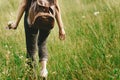 Stylish hipster woman walking in grass and holding in hand herb Royalty Free Stock Photo