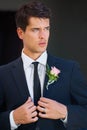 Stylish on his big day. A handsome groom wearing a pink rose on his jacket isolated on a black background. Royalty Free Stock Photo