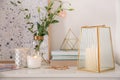 Stylish holder with burning candle, books and decor on white table Royalty Free Stock Photo